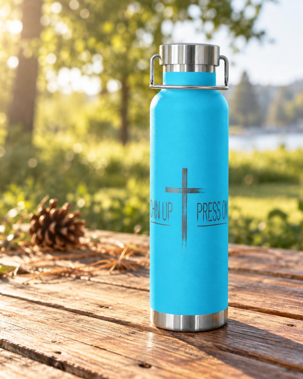 Pebble blue insulated bottle with the CHIN UP PRESS ON design on an outdoor wooden table.